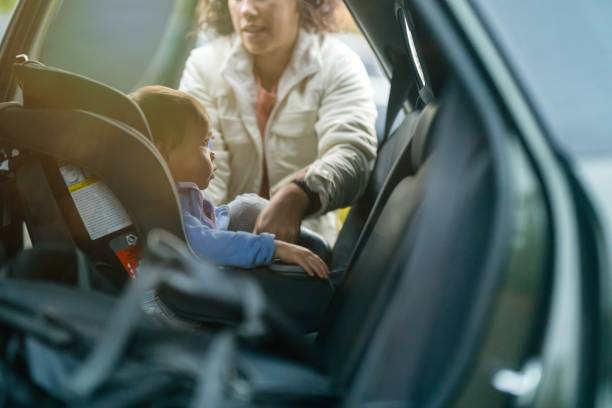 parent hug a baby into a car seat