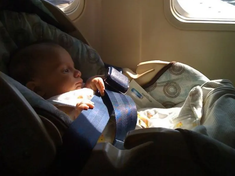 baby sitting on the car seat on the plane 2